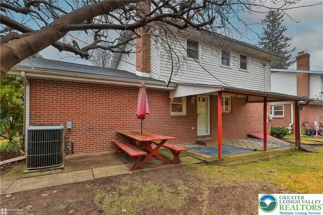 a view of a house with a yard and wooden fence