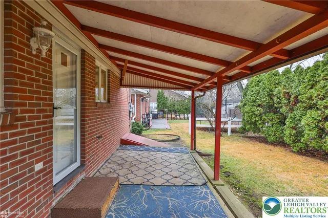 a view of a backyard with table and chairs under an umbrella
