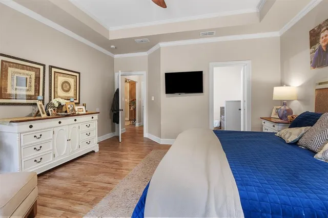 a spacious bedroom with a large bed and a flat tv screen on a dresser