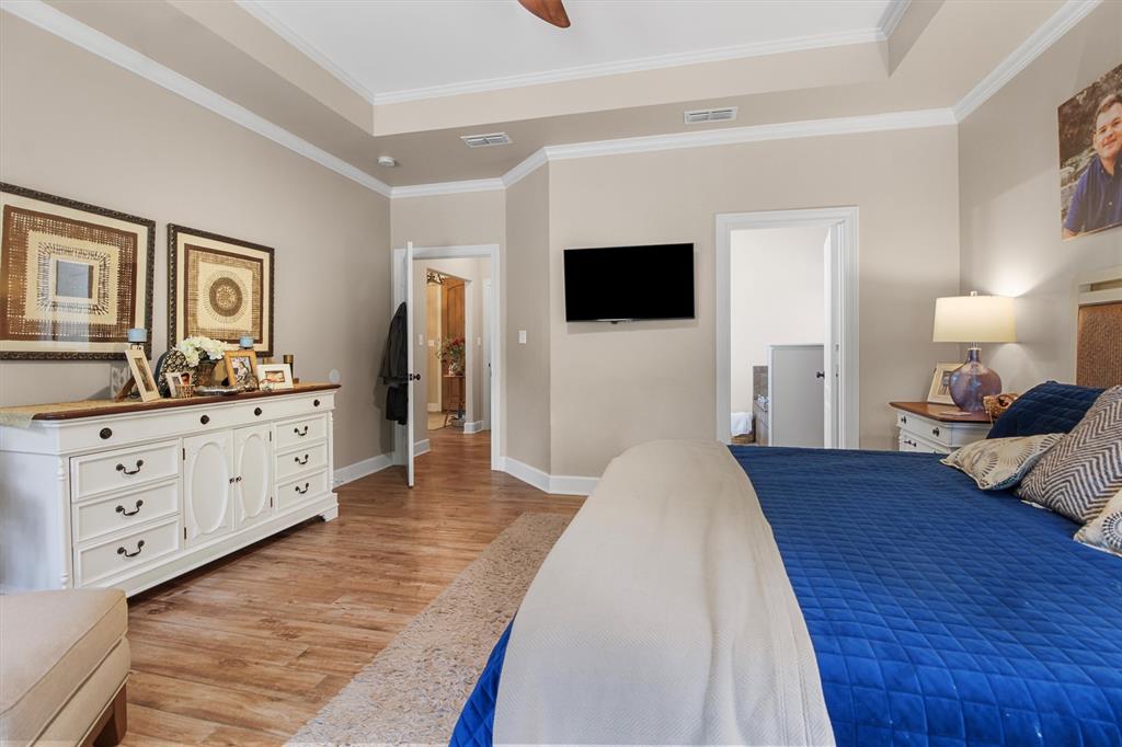 18551 Lazy Lane Flint, TX 75762 - Photo 22 of 39 a spacious bedroom with a large bed and a flat tv screen on a dresser