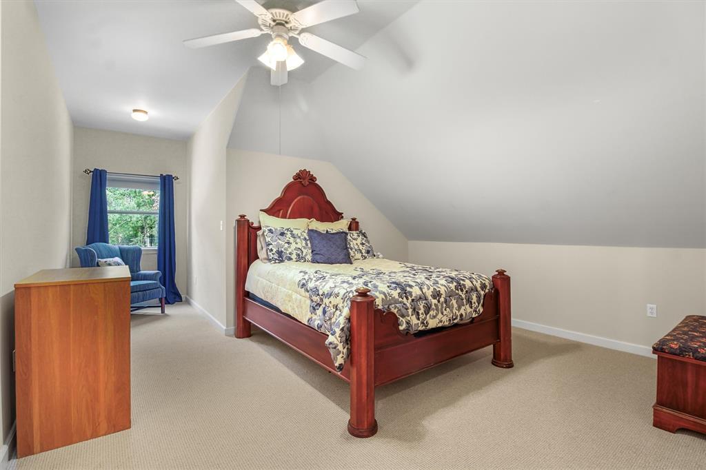 18551 Lazy Lane Flint, TX 75762 - Photo 34 of 39 a bedroom with a bed and a chandelier