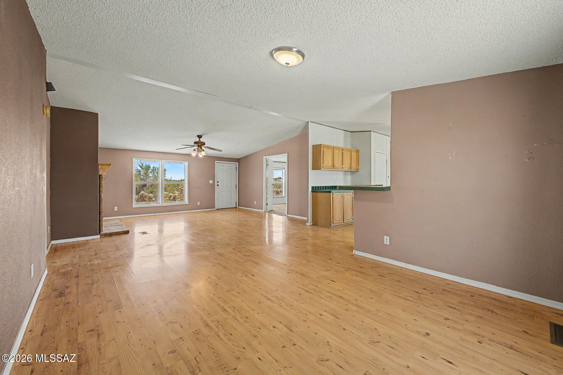 1911 West Thunder Road Vail, AZ 85641 - Photo 8 of 38 a view of an empty room with wooden floor and a window
