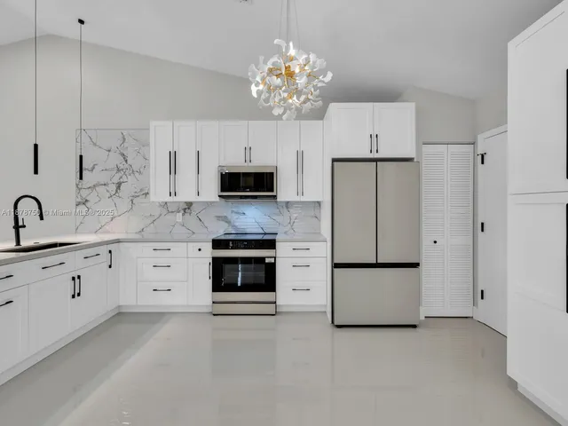 a bathroom with a sink a faucet a lamp and a chandelier