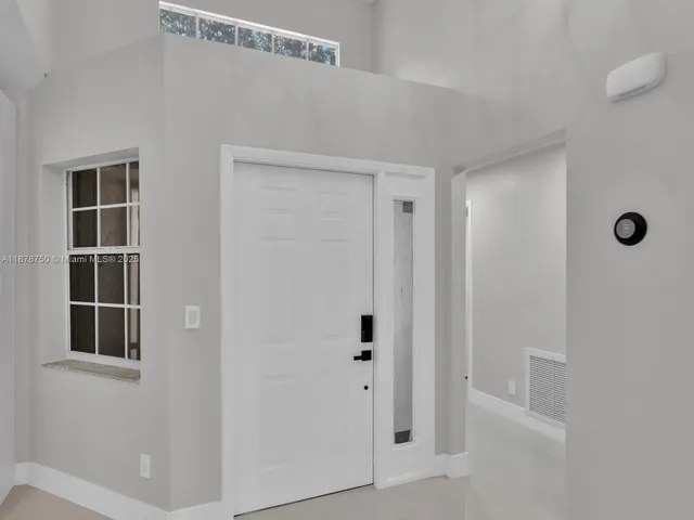 a large white kitchen with a sink and dishwasher