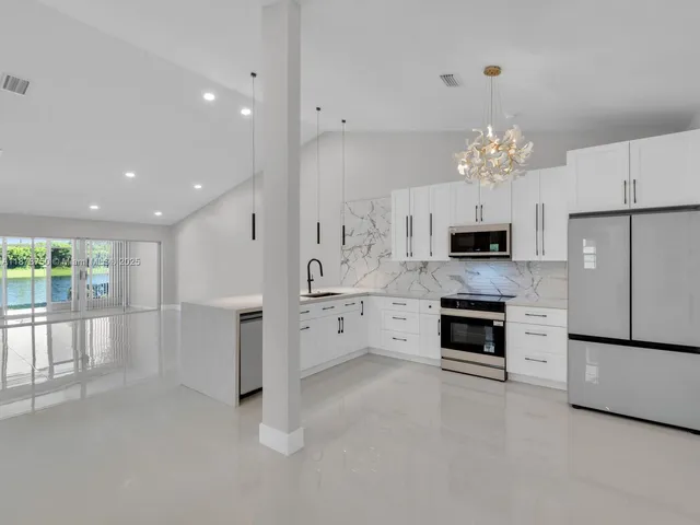 a view of a kitchen with a sink and refrigerator
