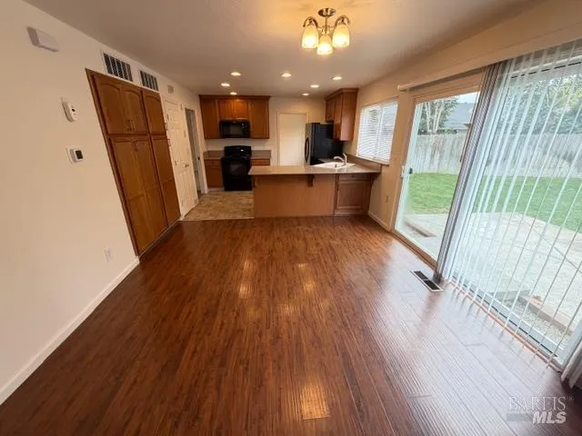 a view of a kitchen with wooden floor and electronic appliances