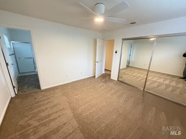 an empty room with wooden floor and staircase