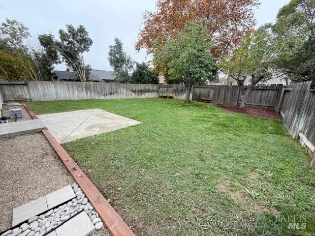 a view of a backyard with wooden fence