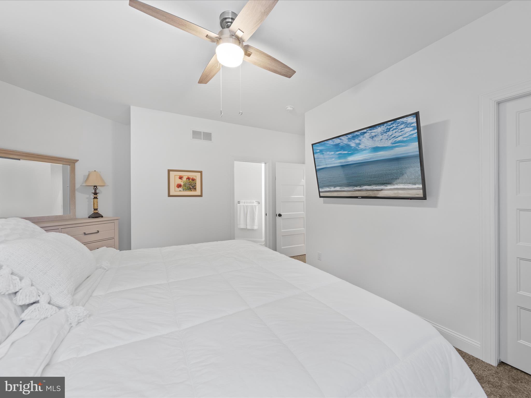 20005 Devine Way Milton, DE 19968 - Photo 37 of 82 a bedroom with a large bed and a chandelier