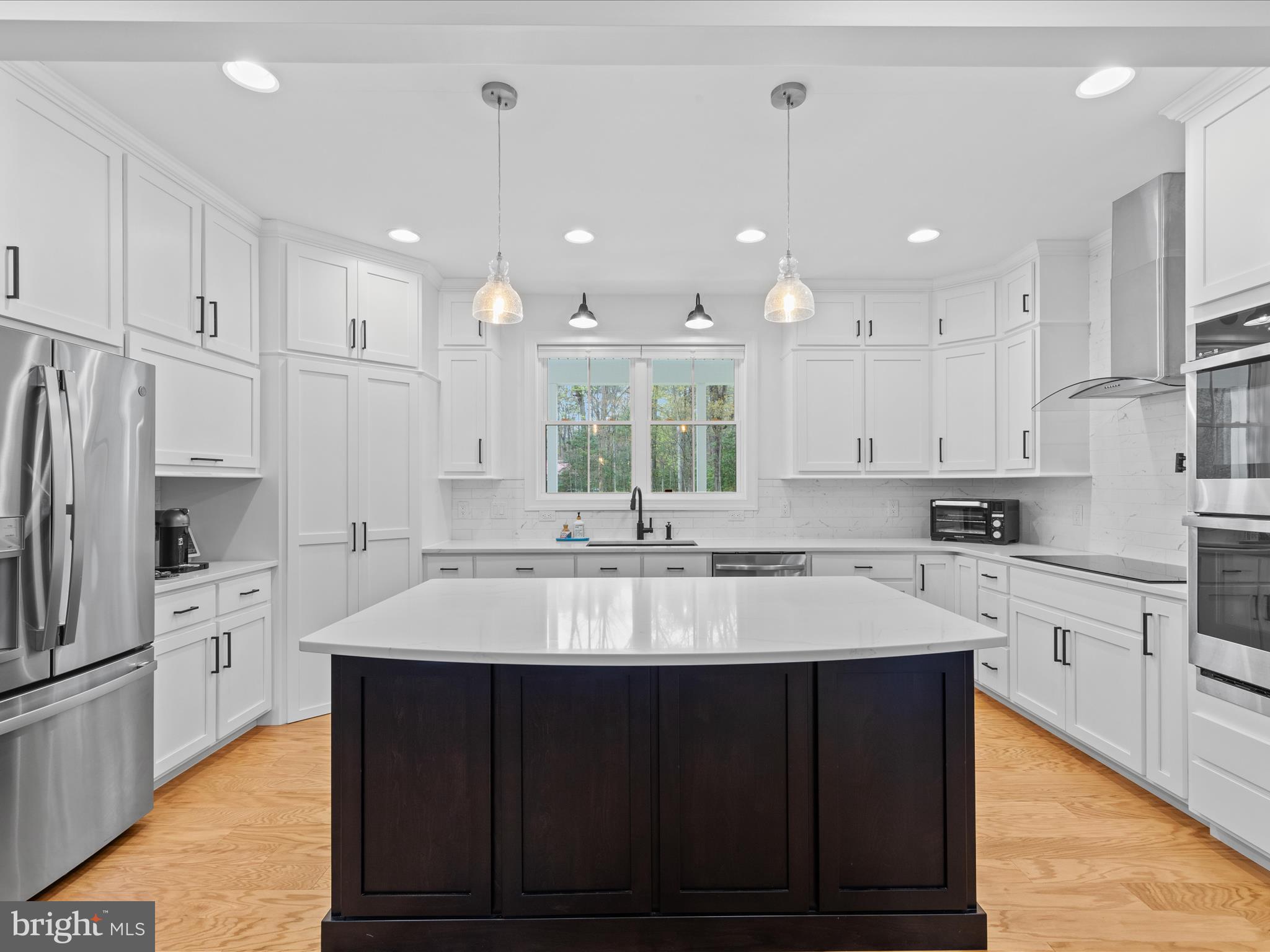 20005 Devine Way Milton, DE 19968 - Photo 7 of 82 a large kitchen with kitchen island a sink white cabinets and stainless steel appliances