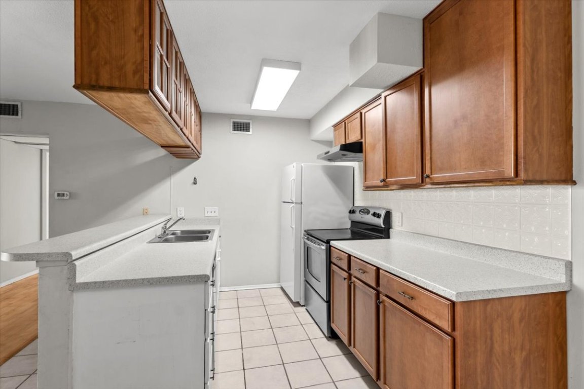 910 Duncan Lane, Unit 57 Austin, TX 78705 - Photo 11 of 34 a kitchen with stainless steel appliances a sink stove and cabinets