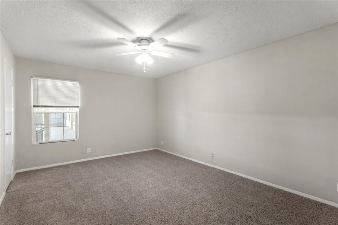 910 Duncan Lane, Unit 57 Austin, TX 78705 - Photo 23 of 34 an empty room with windows and fan