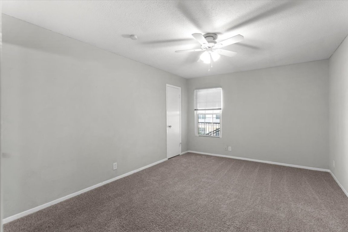 910 Duncan Lane, Unit 57 Austin, TX 78705 - Photo 24 of 34 an empty room with windows and fan