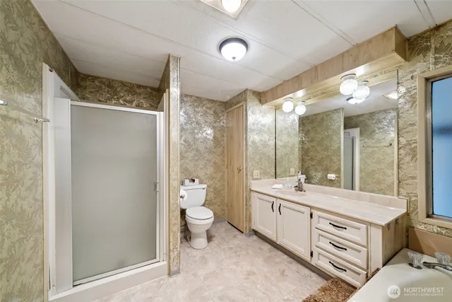 a spacious bathroom with a double vanity sink a mirror and a shower