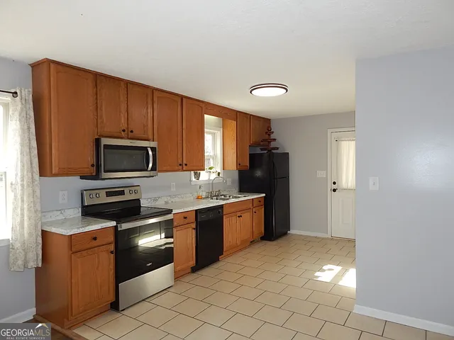 a kitchen with stainless steel appliances granite countertop a refrigerator and a stove top oven