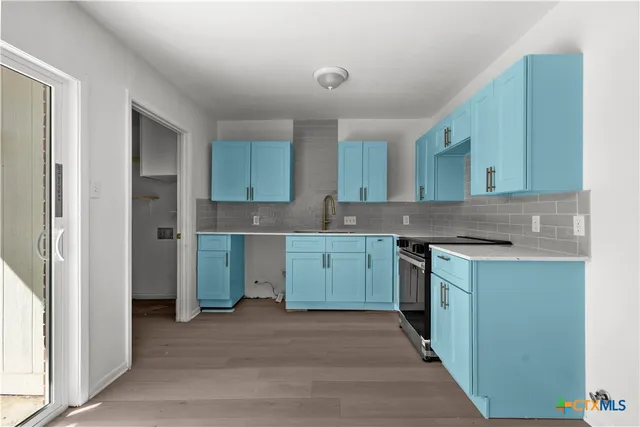 a kitchen with a sink stove and cabinets