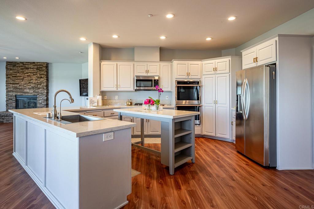 30606 Falling Star Circle Valley Center, CA 92082 - Photo 32 of 70 a kitchen with kitchen island wooden floors appliances and cabinets