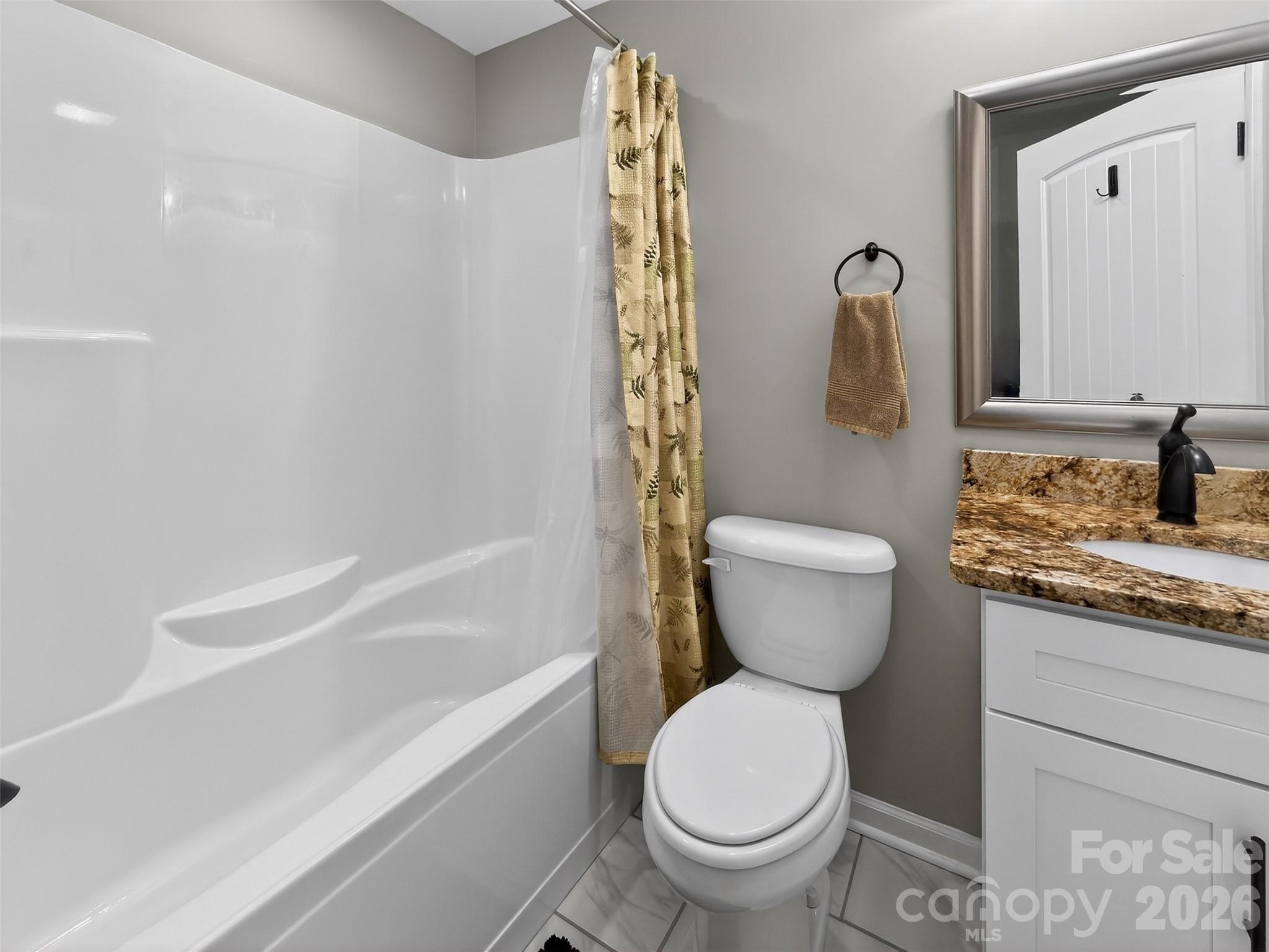 116 Bostic Street Marion, NC 28752 - Photo 22 of 28 a bathroom with a granite countertop toilet a sink and a bathtub