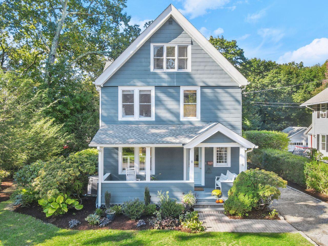 a front view of a house with a yard and potted plants