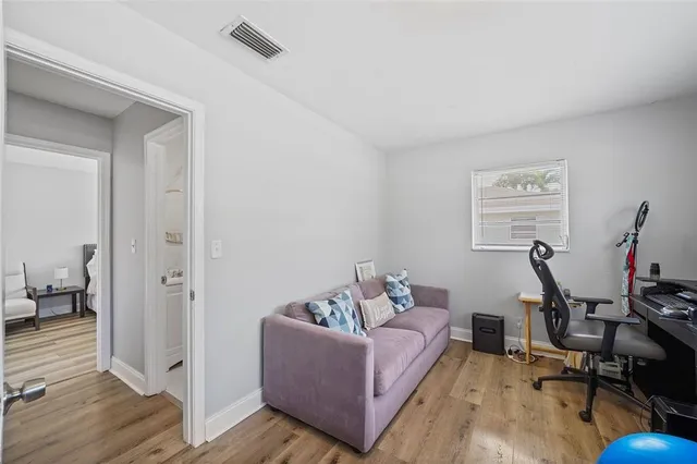 a living room with furniture and a wooden floor
