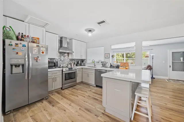 a kitchen with stainless steel appliances a refrigerator sink and cabinets