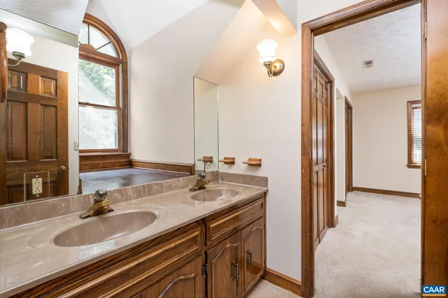 a bed sitting in a bedroom next to a window and a chandelier