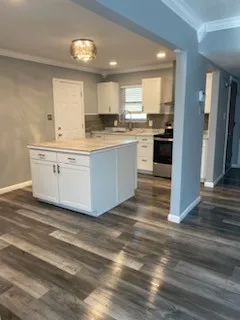 a kitchen with stainless steel appliances kitchen island wooden cabinets and a refrigerator