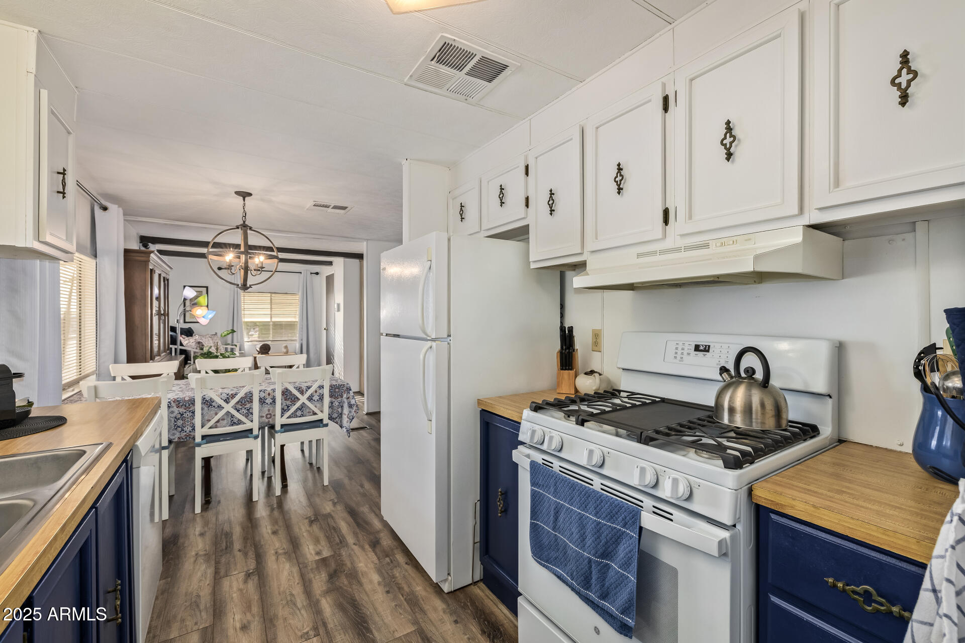 11425 East University Drive, Unit 120 Apache Junction, AZ 85120 - Photo 10 of 43 a kitchen with granite countertop a stove a sink dishwasher and a refrigerator with wooden floor