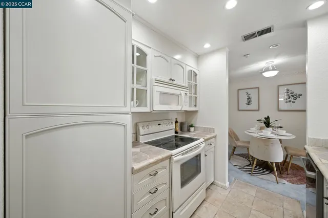 a kitchen with cabinets and chairs