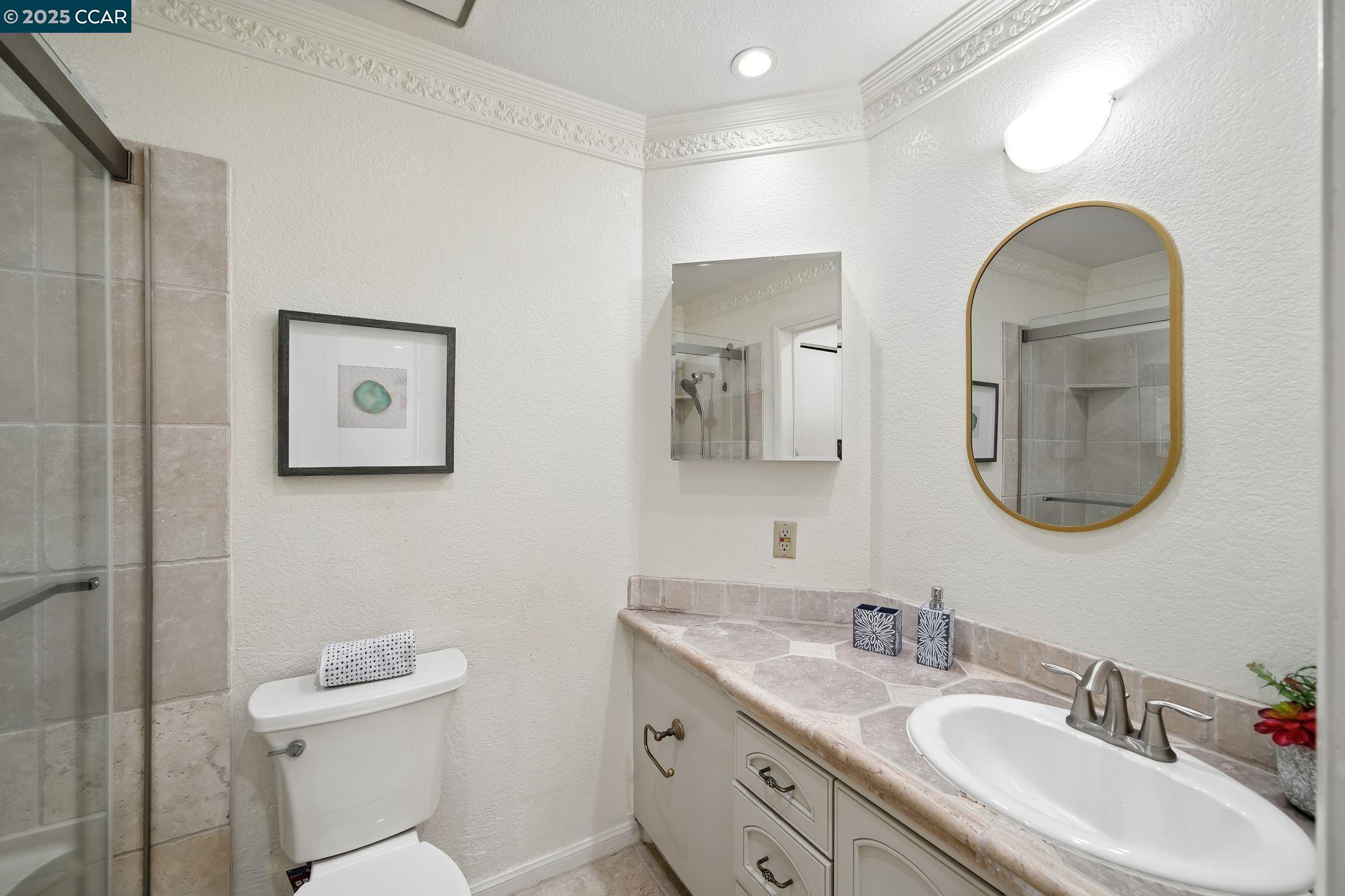 3183 Wayside Plaza, Unit 320 Walnut Creek, CA 94597 - Photo 20 of 34 a bathroom with a toilet a sink and mirror
