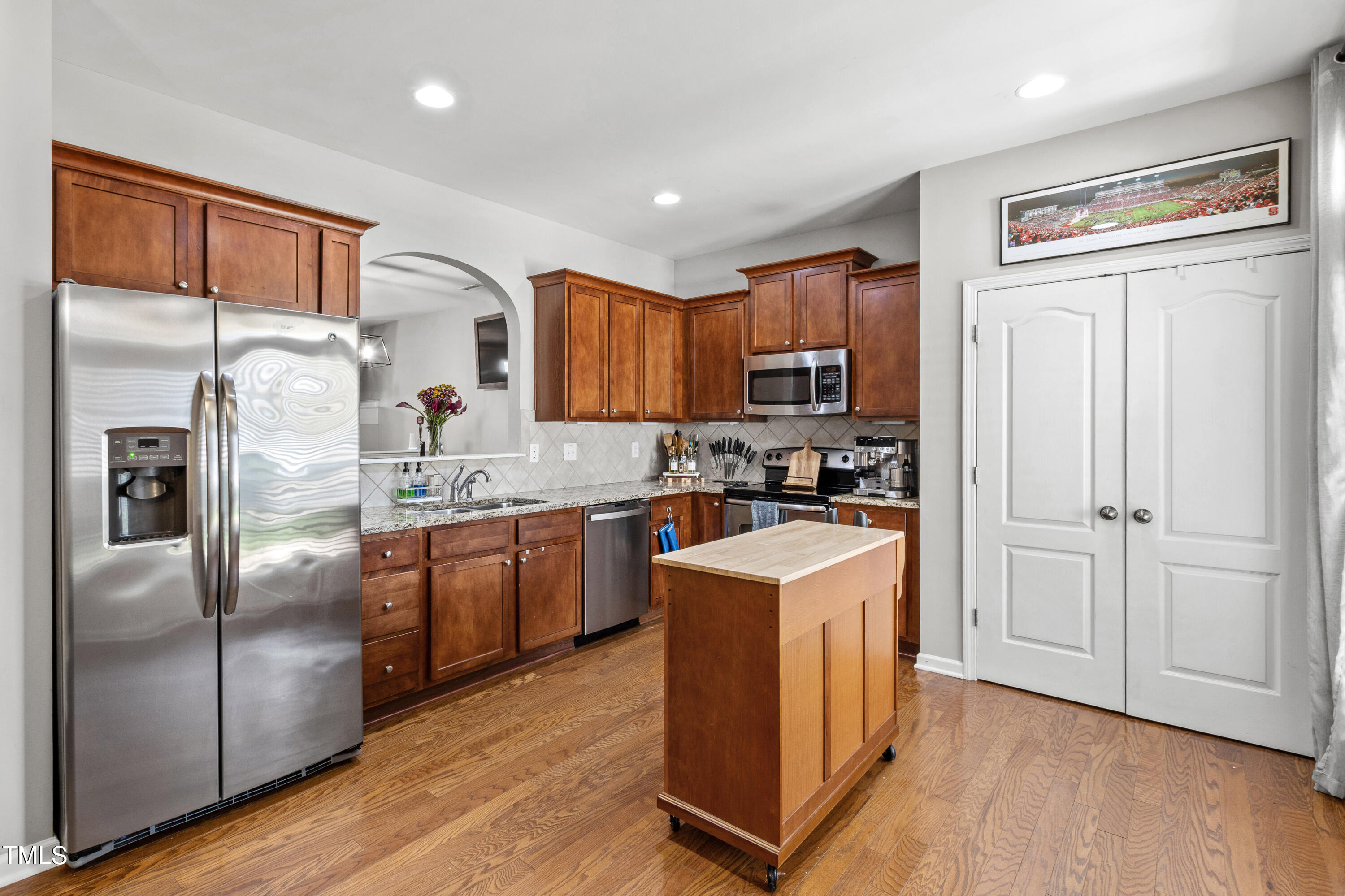 1322 Regulator Street Raleigh, NC 27603 - Photo 18 of 58 a kitchen with granite countertop stainless steel appliances a refrigerator a stove top oven a sink and cabinets