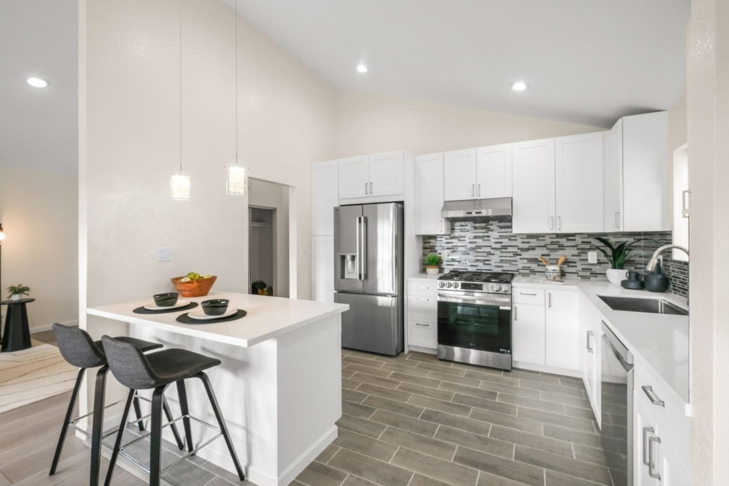415 C Street Colma, CA 94014 - Photo 16 of 57 a kitchen with stainless steel appliances kitchen island granite countertop a stove a sink a refrigerator and a refrigerator
