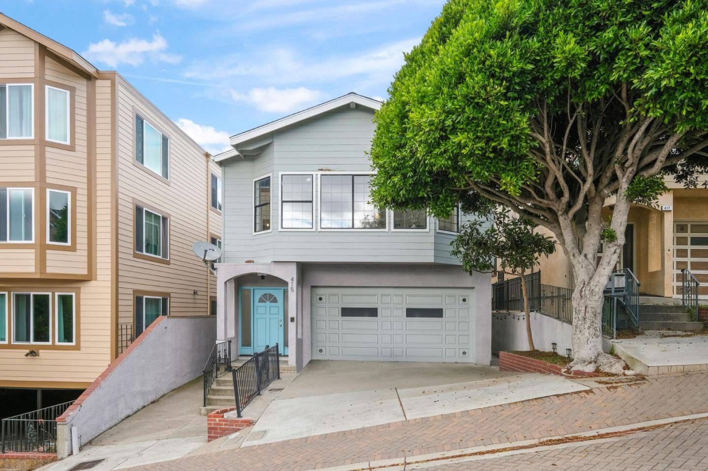415 C Street Colma, CA 94014 - Photo 3 of 57 a front view of a house with garage and glass top table and chairs