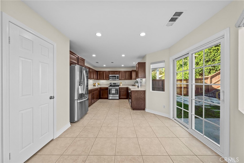 11344 Magnolia Street Corona, CA 92883 - Photo 19 of 75 a view of a kitchen with kitchen island granite countertop lots of counter top space a refrigerator and windows