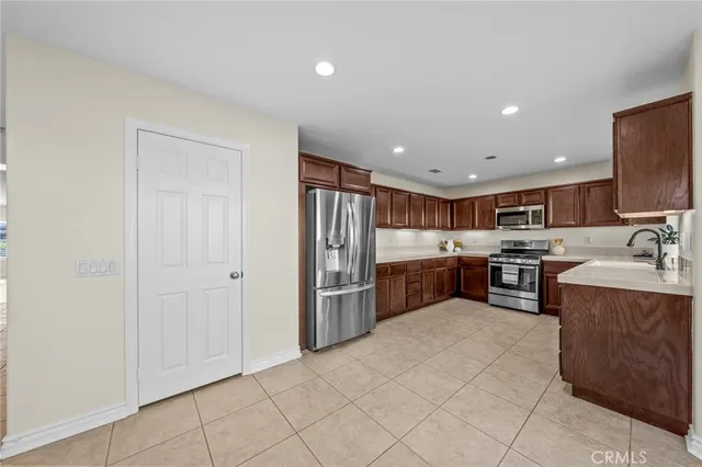 a kitchen with stainless steel appliances granite countertop a stove top oven a sink dishwasher and a refrigerator