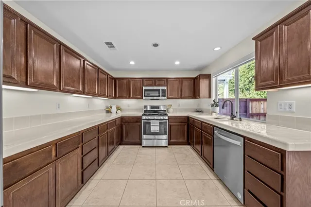 a kitchen with stainless steel appliances granite countertop a refrigerator and a sink