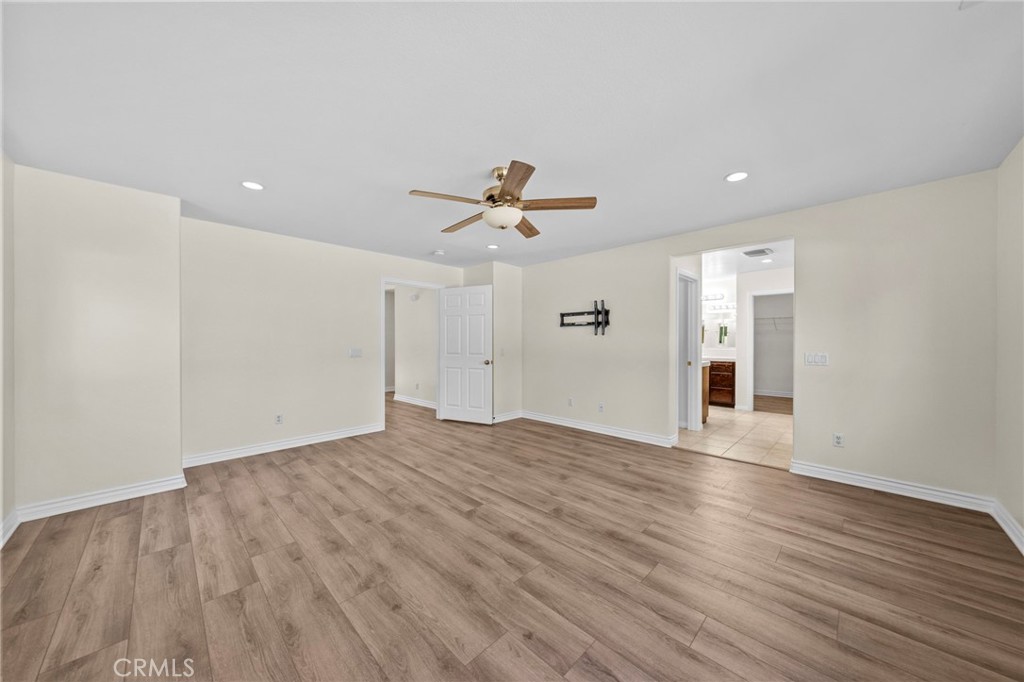 11344 Magnolia Street Corona, CA 92883 - Photo 35 of 75 a view of an empty room with wooden floor and a ceiling fan