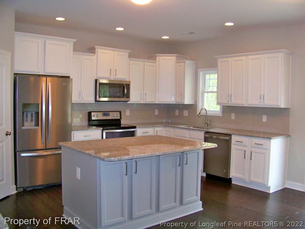 160 Cashew Loop Carthage, NC 28326 - Photo 7 of 16 a kitchen with stainless steel appliances granite countertop a sink a stove a refrigerator a window and a cabinets