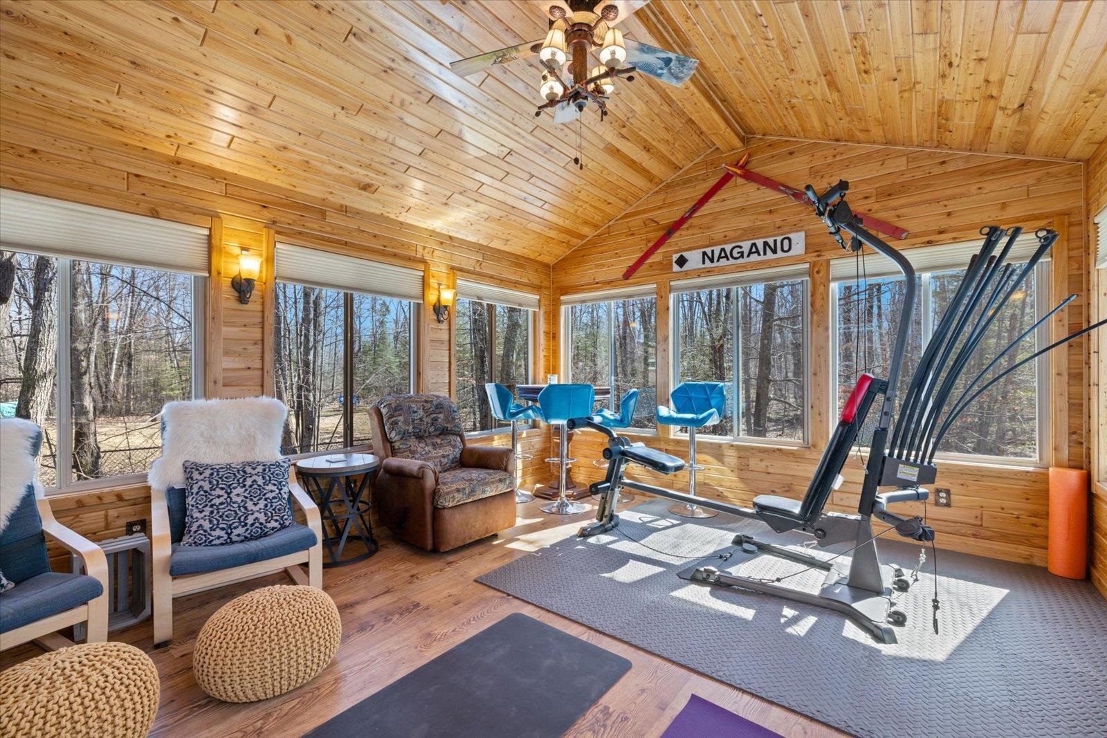 717 Bourgin Road Virginia, MN 55792 - Photo 20 of 47 Workout room with vaulted ceiling, a ceiling fan, wood walls, wood finished floors, and wood ceiling