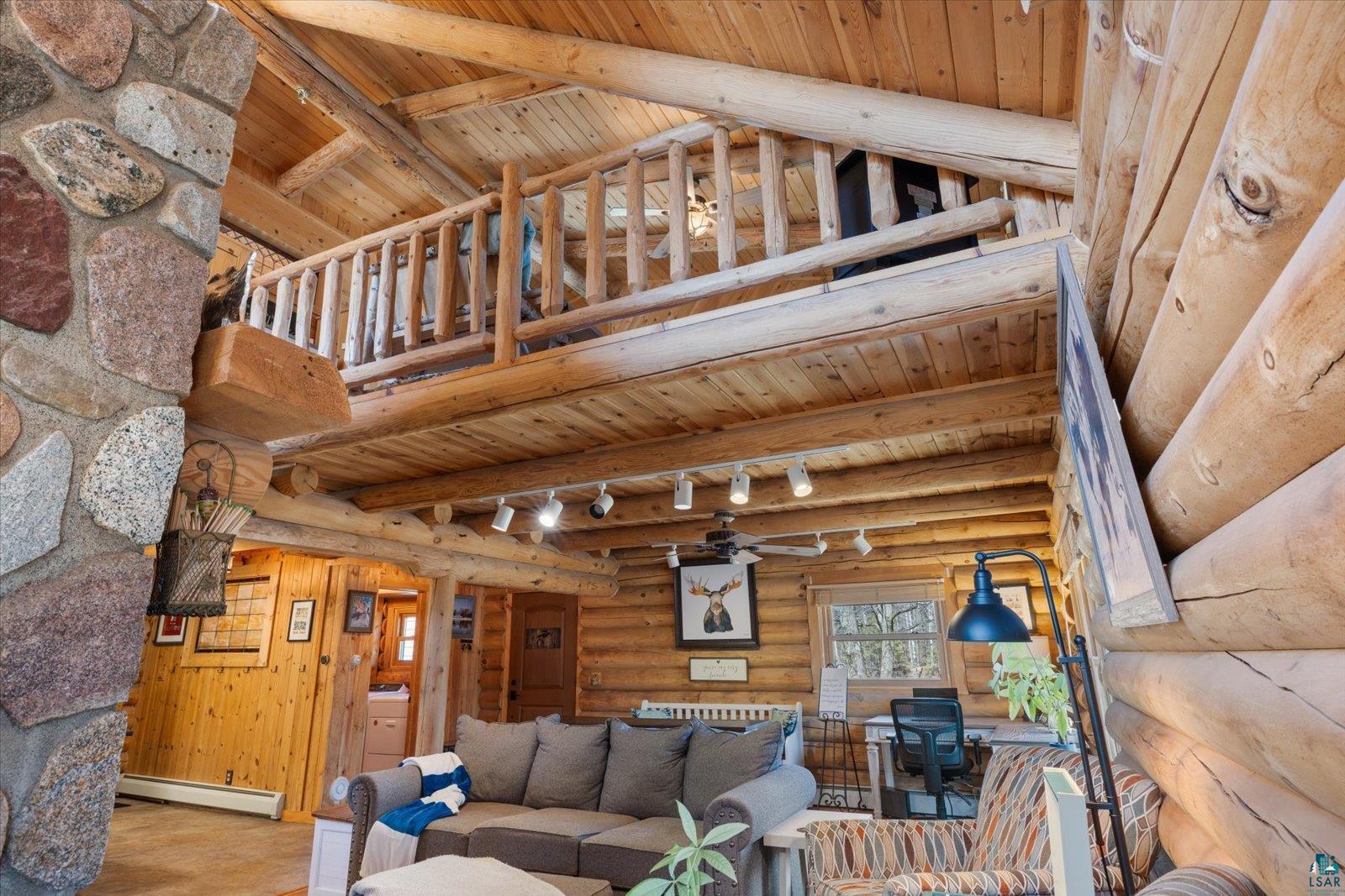 717 Bourgin Road Virginia, MN 55792 - Photo 23 of 47 Living area featuring wooden ceiling, baseboard heating, beamed ceiling, track lighting, and log walls