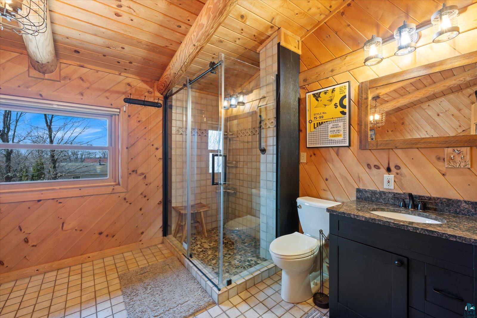 717 Bourgin Road Virginia, MN 55792 - Photo 31 of 47 Bathroom with wood walls, a shower stall, wood ceiling, vanity, and toilet
