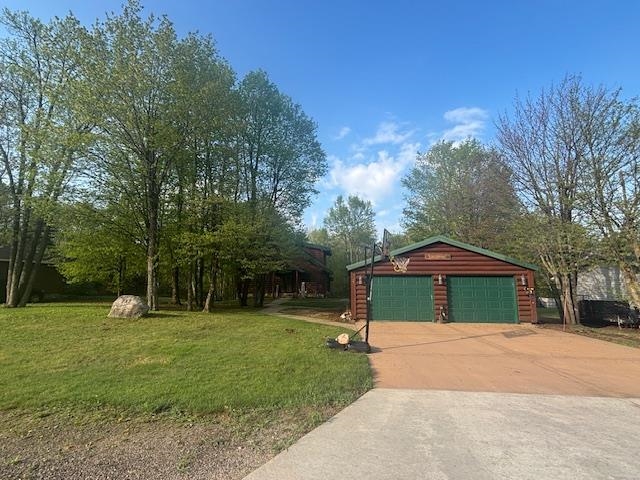 717 Bourgin Road Virginia, MN 55792 - Photo 46 of 47 View of front of property featuring a front yard, concrete driveway, faux log siding, and a garage