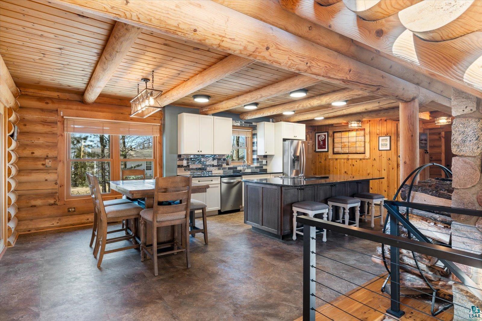 717 Bourgin Road Virginia, MN 55792 - Photo 9 of 47 Dining space with healthy amount of natural light, rustic walls, wooden ceiling, and beam ceiling