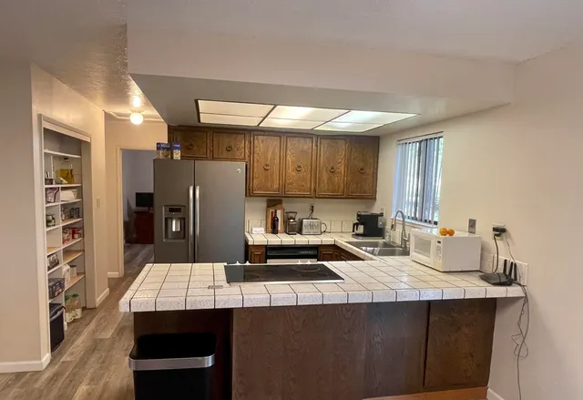 a kitchen with stainless steel appliances a sink cabinets and wooden floor