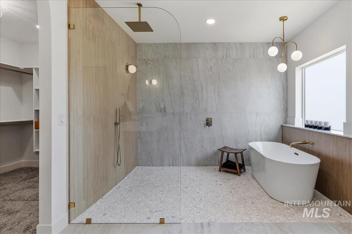 2005 Sparrow Street Rupert, ID 83350 - Photo 17 of 30 Spacious bathroom featuring a frameless glass shower enclosure, a freestanding soaking tub, and a rain showerhead
