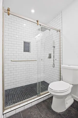 a bathroom with a toilet and a shower