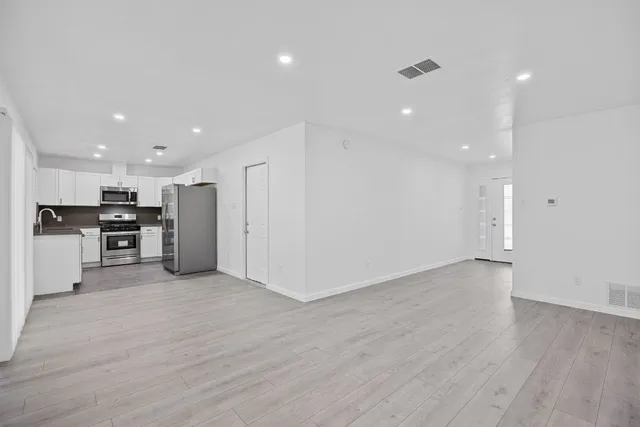 a view of an empty room with wooden floor
