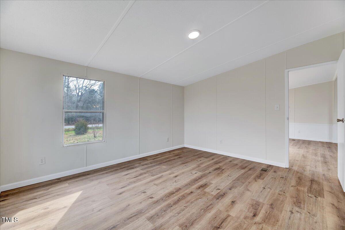 10942 Simms Road Bailey, NC 27807 - Photo 13 of 44 an empty room with wooden floor and windows