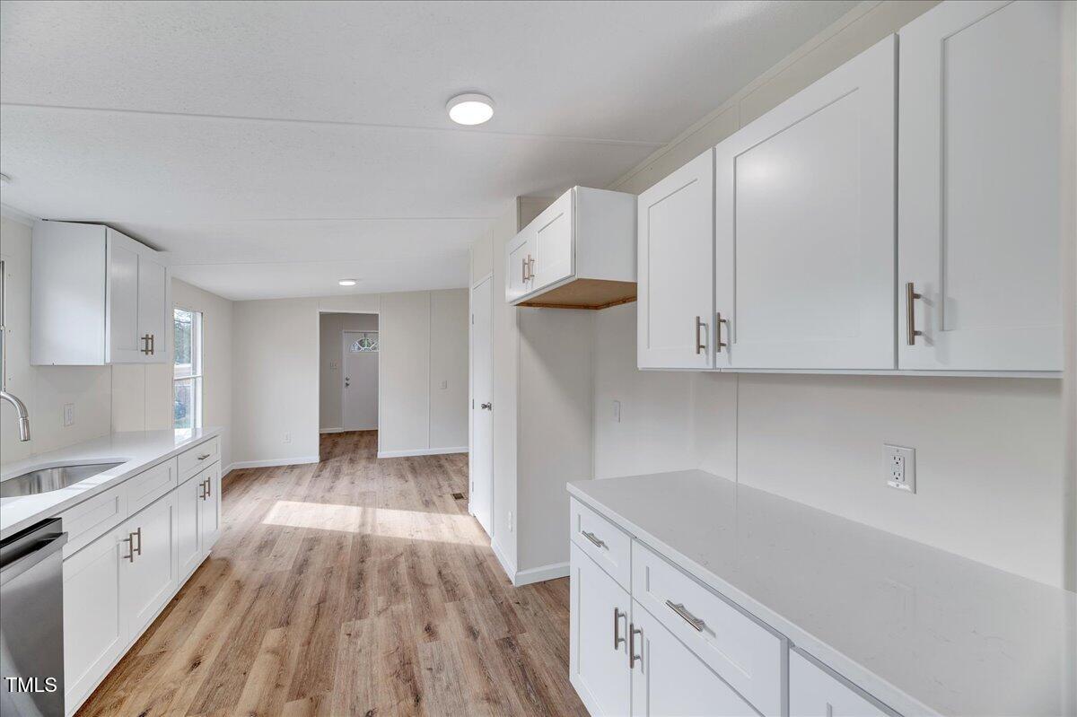 10942 Simms Road Bailey, NC 27807 - Photo 18 of 44 a kitchen with cabinets and wooden floor