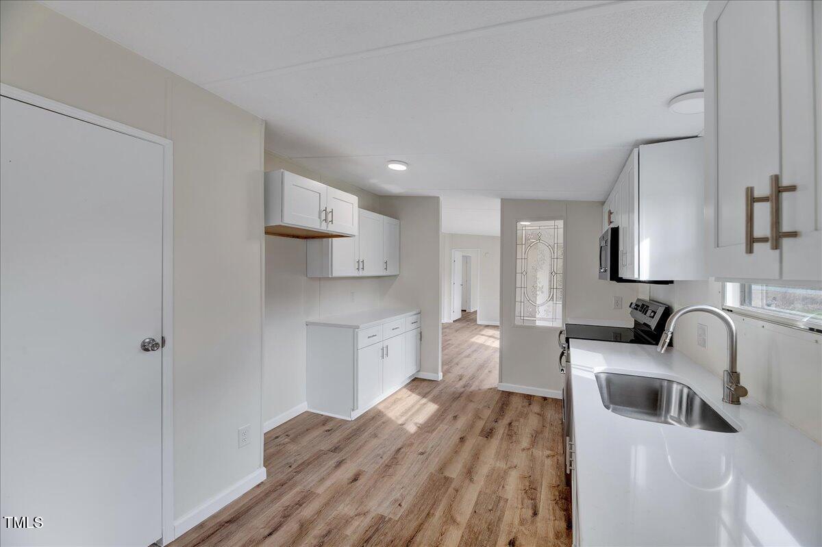10942 Simms Road Bailey, NC 27807 - Photo 22 of 44 a kitchen with a sink and wooden floor